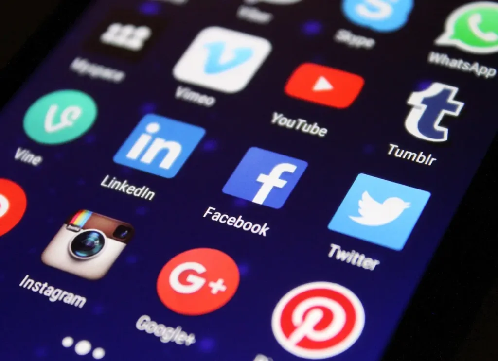 Iconos de redes sociales como Facebook, Instagram, Twitter, YouTube y LinkedIn en la pantalla de un móvil, representando su uso dentro de las estrategias de marketing digital.
